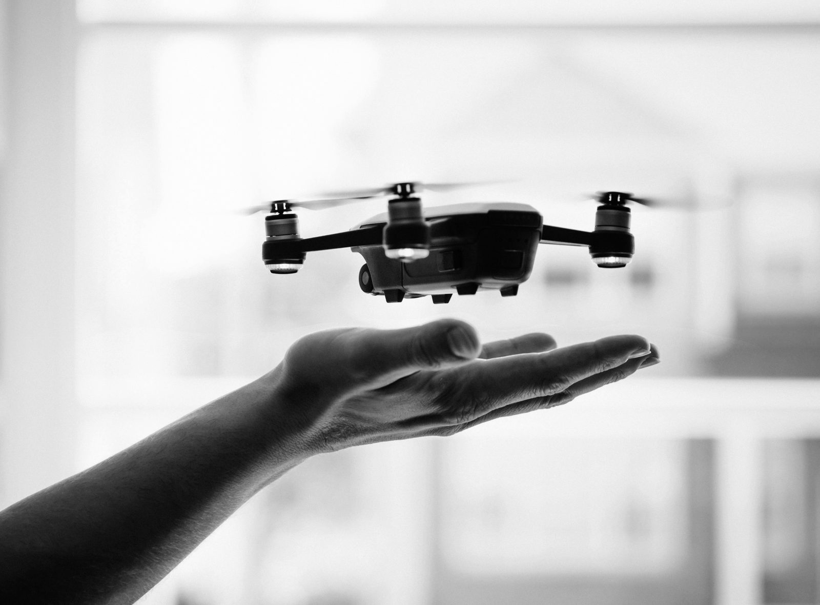 A drone hovering above an open hand
